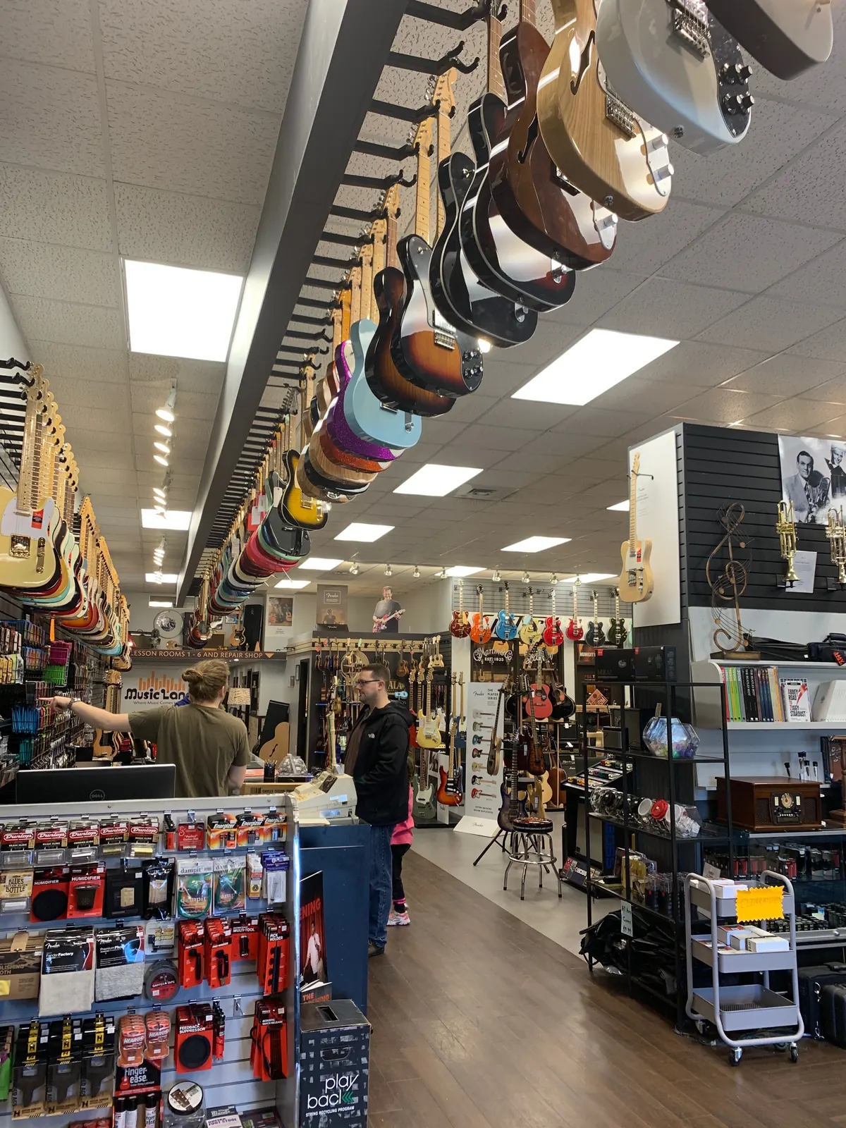 Music Land employee helping a customer choose a musical instrument in Bel Air MD